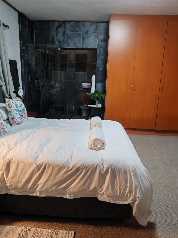 una camera da letto con un letto e un asciugamano sopra di Hidden Gem a George