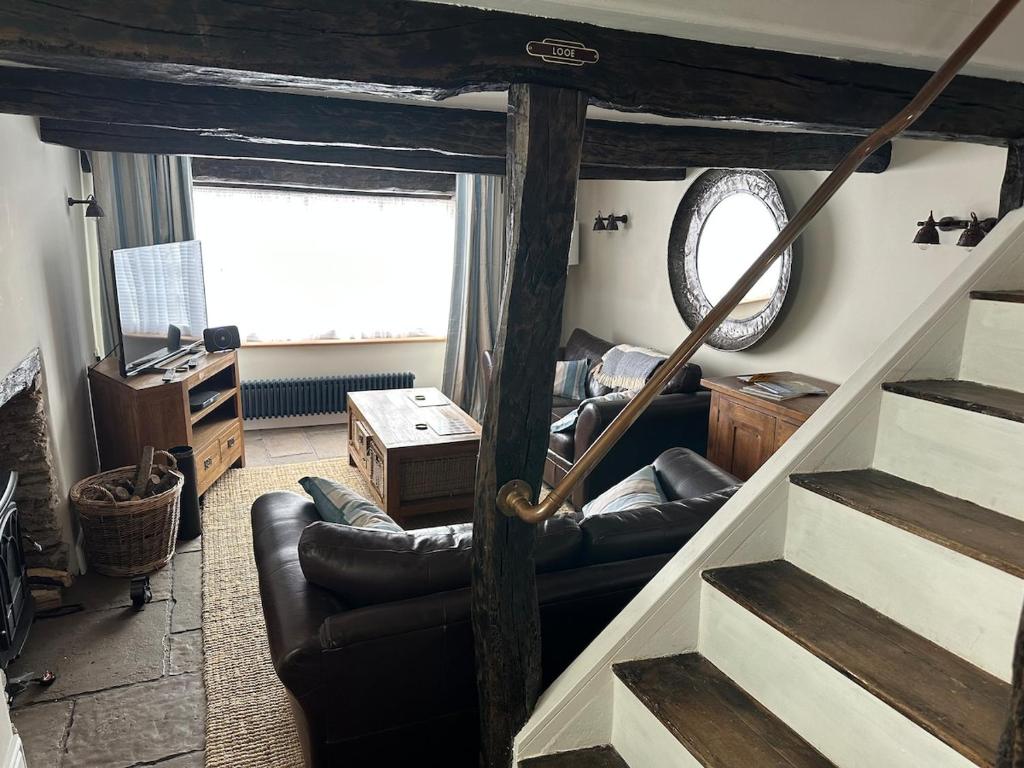 un soggiorno con divani e una scala a chiocciola di Character 3 Bed Cottage, Close to Waters edge, Parking a Looe