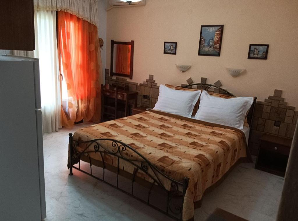 a bedroom with a large bed with white pillows at Πανσιόν Άγγελος in Ouranoupoli