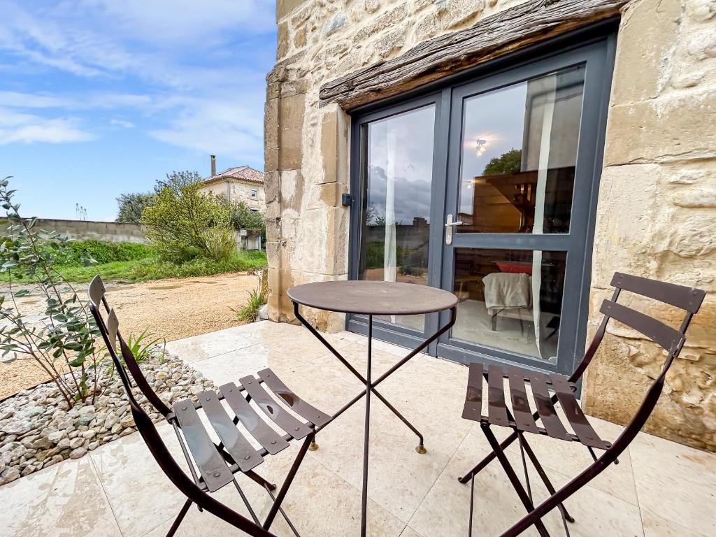 une table et deux chaises sur une terrasse dans l'établissement Charmant Duplex Avec Terrasse, à Châteauneuf-sur-Isère