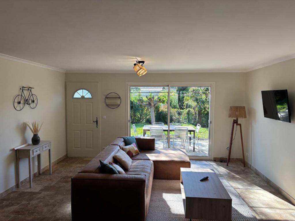 a living room with a couch and a table at Maison en Pierre à Gordes avec Jacuzzi Chauffé - Très belle vue sur le Village - À 5mn du centre in Gordes