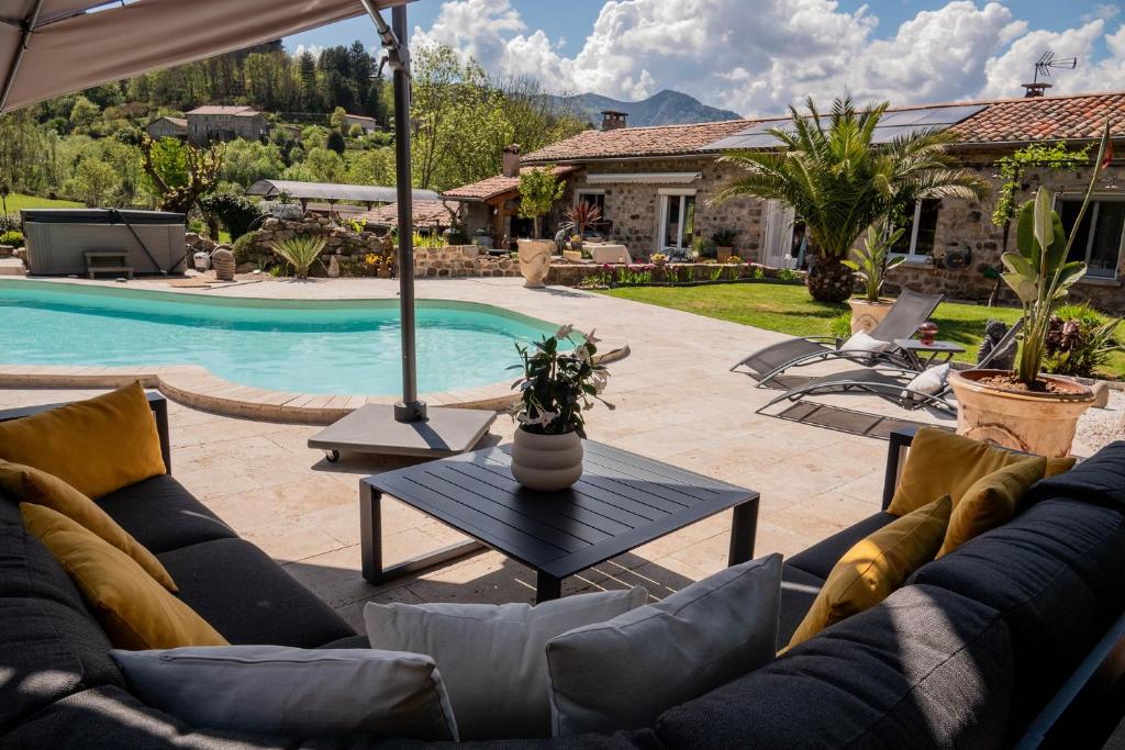 a patio with couches and a table next to a pool at La babounette in Jaujac