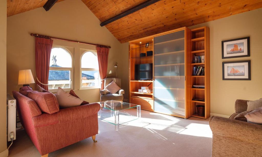 Una sala de estar con un sofá y una mesa de cristal. en Robinson, en Keswick