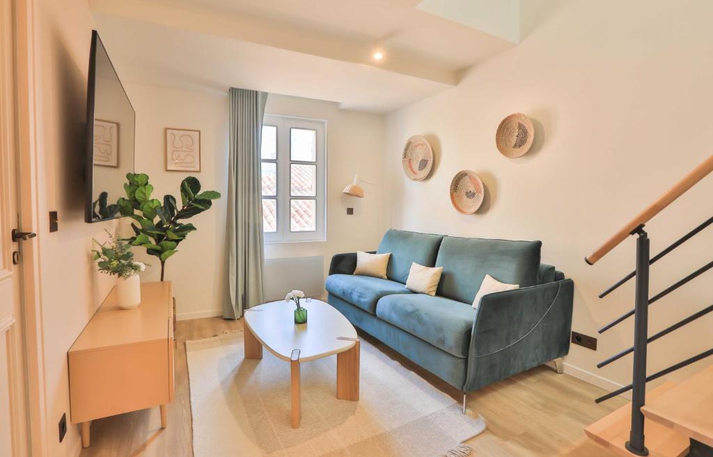 salon z niebieską kanapą i stołem w obiekcie Nice 2 bed flat - Hyper centre St Tropez w Saint-Tropez