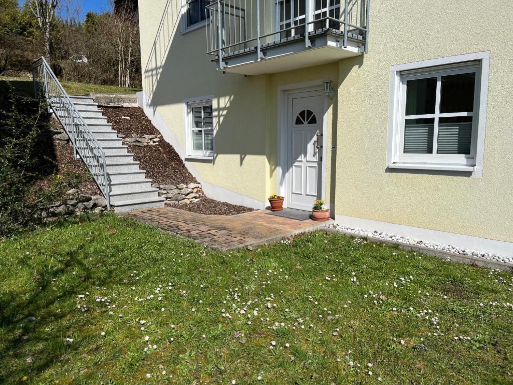a house with a staircase and a balcony on it at Ferienwohnung Sonnengarten in Heiligenstadt