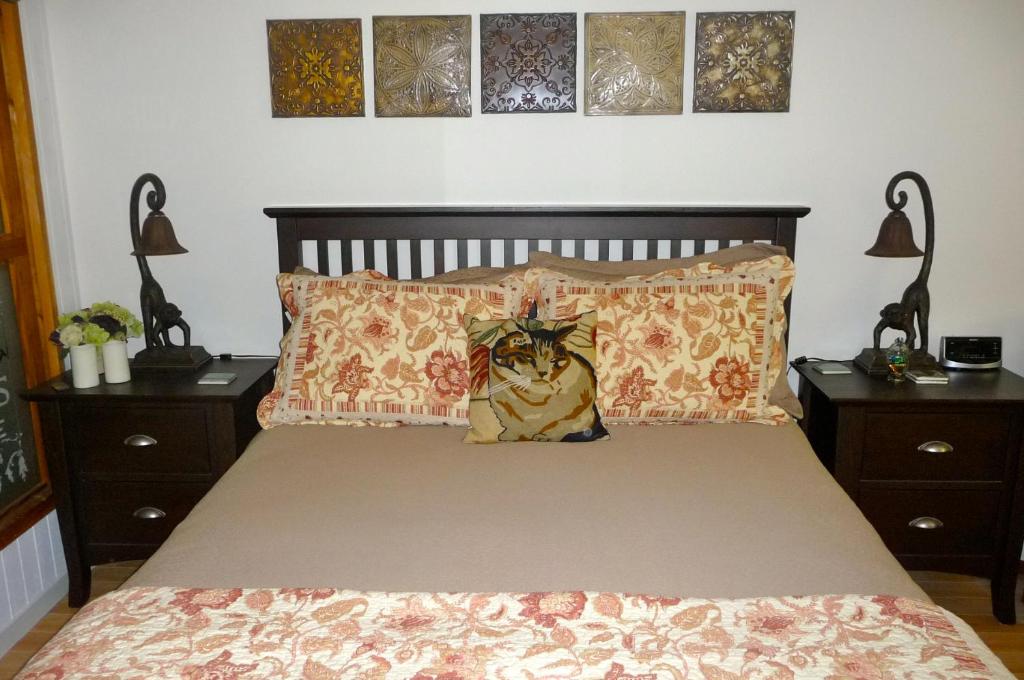 a bedroom with a bed with two nightstands and a bed with a cat at Magnolia Petal in Ganges