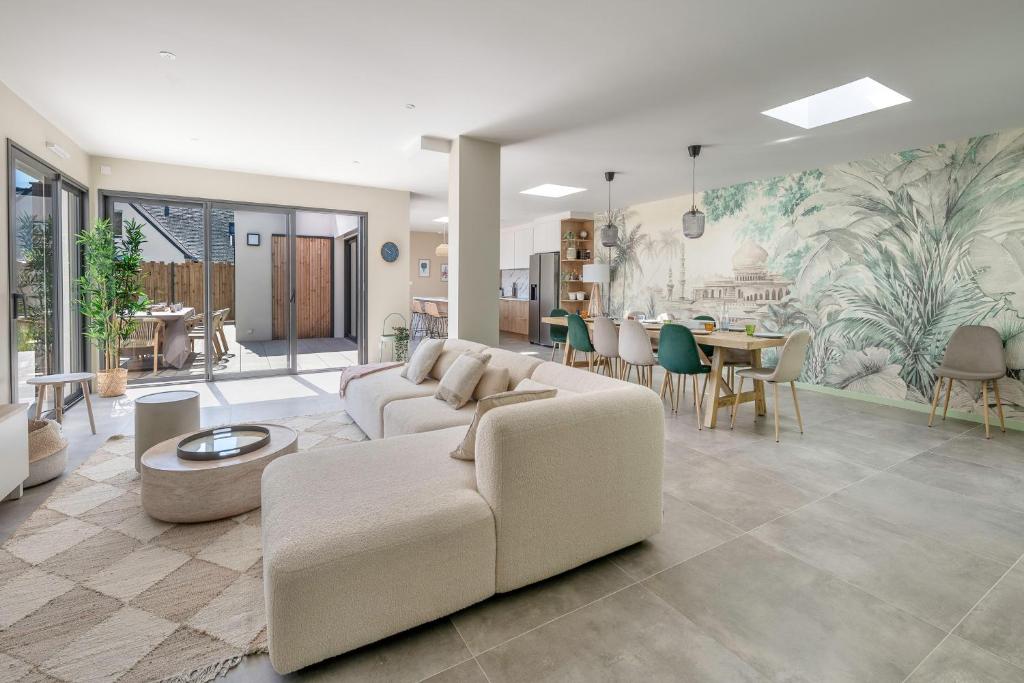 un soggiorno con divano e sala da pranzo di 850m de la mer - Maison 8 adultes et 4 enfants a Piriac-sur-Mer