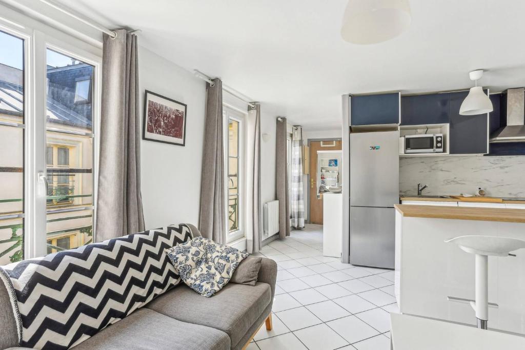 un salon avec un canapé et une cuisine dans l'établissement Ce Rêve Bleu, à Paris