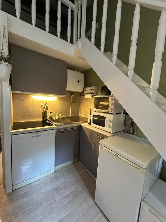 - une cuisine avec un escalier blanc et un réfrigérateur blanc dans l'établissement Appartement CAP D'AGDE 2-4 pers, au Cap d'Agde