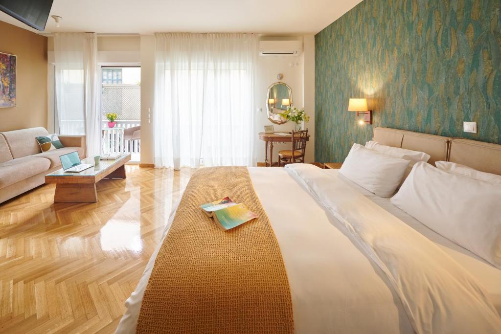 a bedroom with a large bed and a living room at Rastoni Athens Suites near Acropolis in Athens