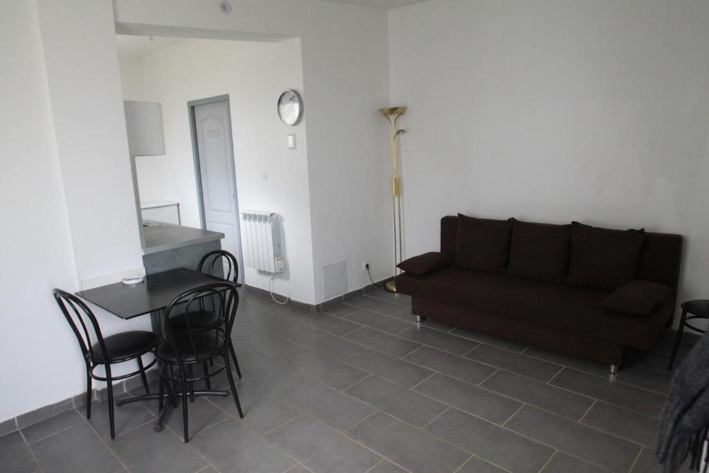 a living room with a couch and a table and chairs at Nice modern house, bright and quiet assured in Nantes