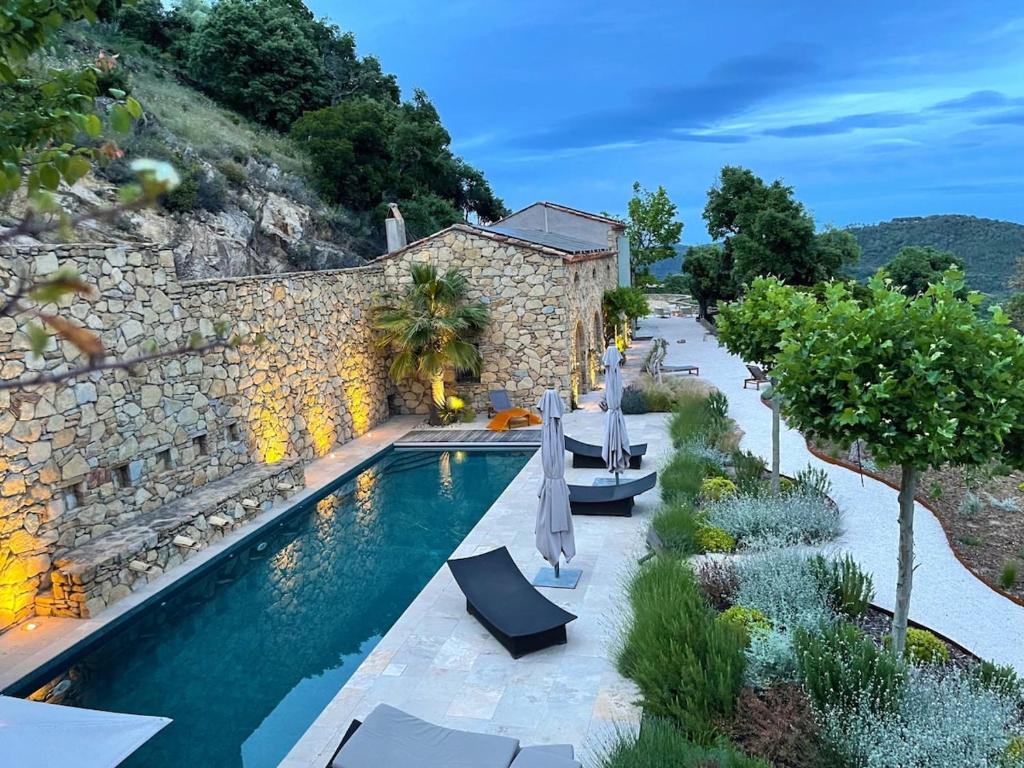 Cette villa dispose d'une piscine et d'un mur en pierre. dans l'établissement Authentic renovated villa, pool, magnificent view, à La Garde-Freinet