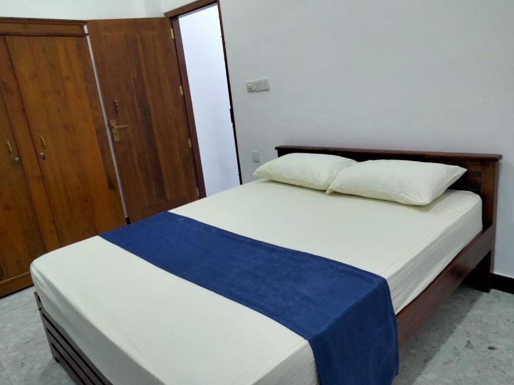 Un dormitorio con dos camas y un armario de madera. en Check Inn Motel, en Nikawatawana