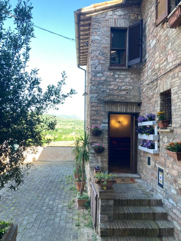- un bâtiment en pierre avec un escalier menant à une porte dans l'établissement Sogni d'Oro Spello, à Spello