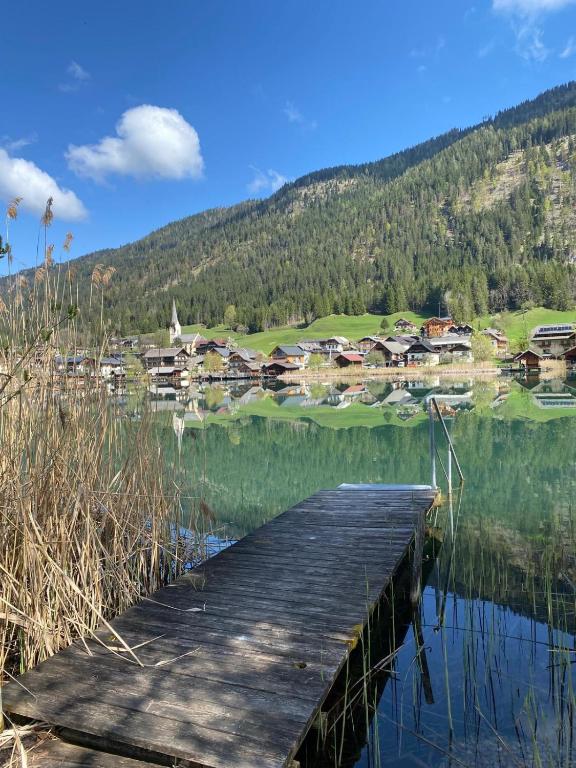a wooden bridge over a body of water with houses at Techendorf 101 in Weissensee