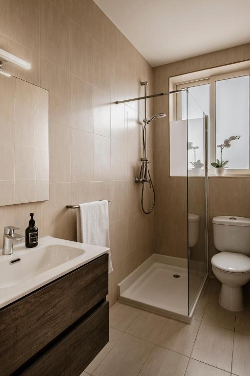 a bathroom with a tub and a toilet and a sink at The Howard Hotel in Sliema