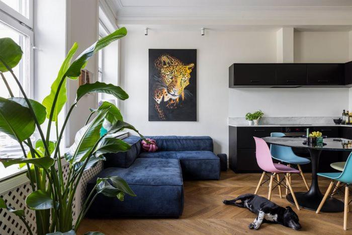 a living room with a blue couch and a table at Luxurious Inner-City Flat in Malmö