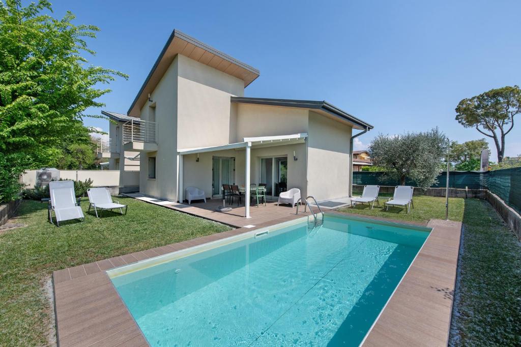une villa avec piscine devant une maison dans l'établissement Le Golfette Ville al Golf 1, à Manerba del Garda