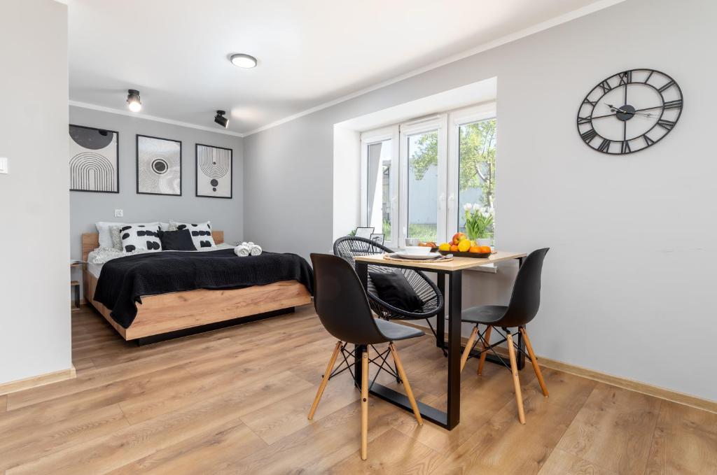 a bedroom with a bed and a table and chairs at Apartament blisko Rynku "Kamienica" in Dębica