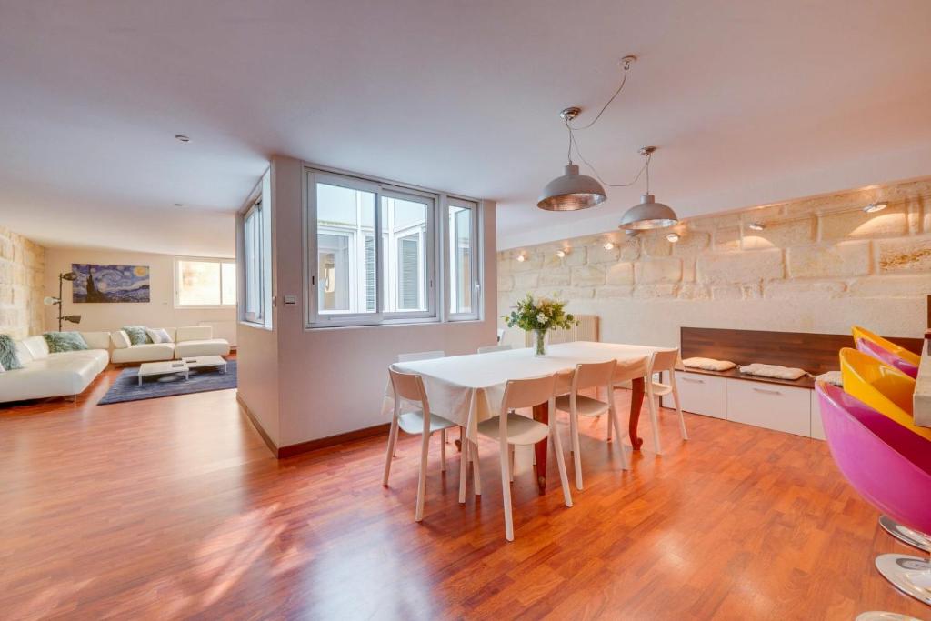 une cuisine et un salon avec une table et des chaises blanches dans l'établissement Spacious, quiet flat in the heart of Bordeaux, à Bordeaux