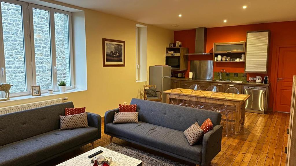 un salon avec deux canapés et une cuisine dans l'établissement L'Appartement d'Egard 8 personnes Normandie, à Tamerville