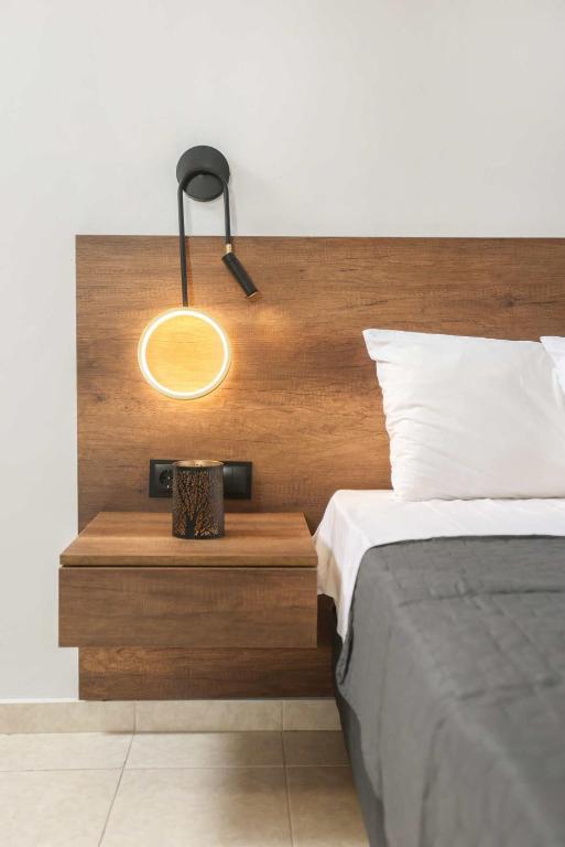 a bedroom with a bed with a wooden headboard at Danae Comfort Living in Pefkochori