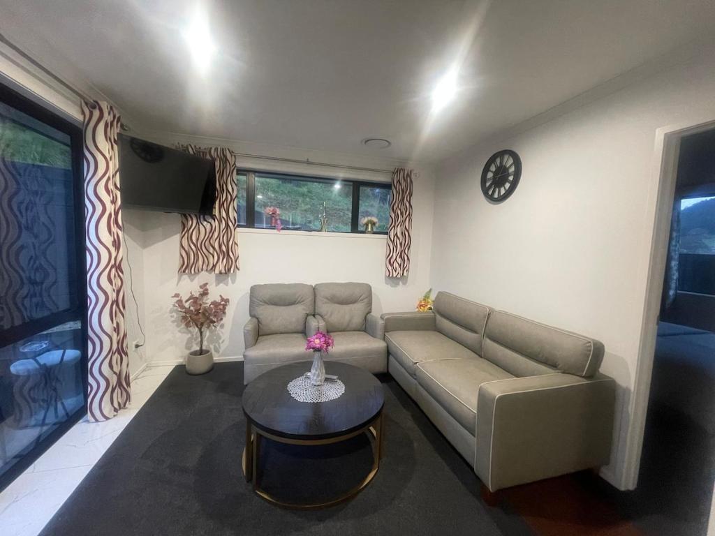 a living room with a couch and a table at Cute Stylish 2 bed Rooms in Rotorua