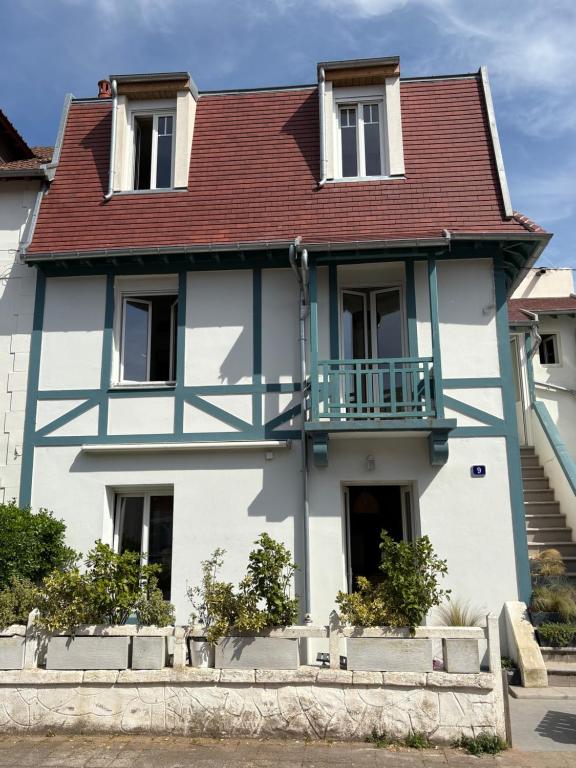 une maison blanche avec un toit rouge dans l'établissement Magnifique maison au bord de la mer, à Le Touquet-Paris-Plage