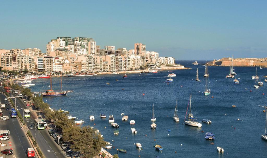 a group of boats in the water next to a city at The Howard Hotel in Sliema