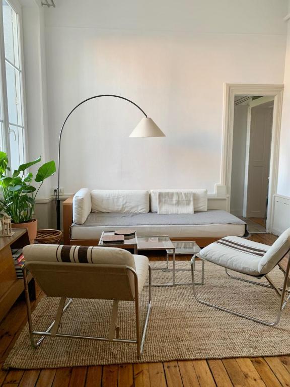 un salon avec un canapé et une table dans l'établissement Appartement spacieux et lumineux Place Delille, à Clermont-Ferrand