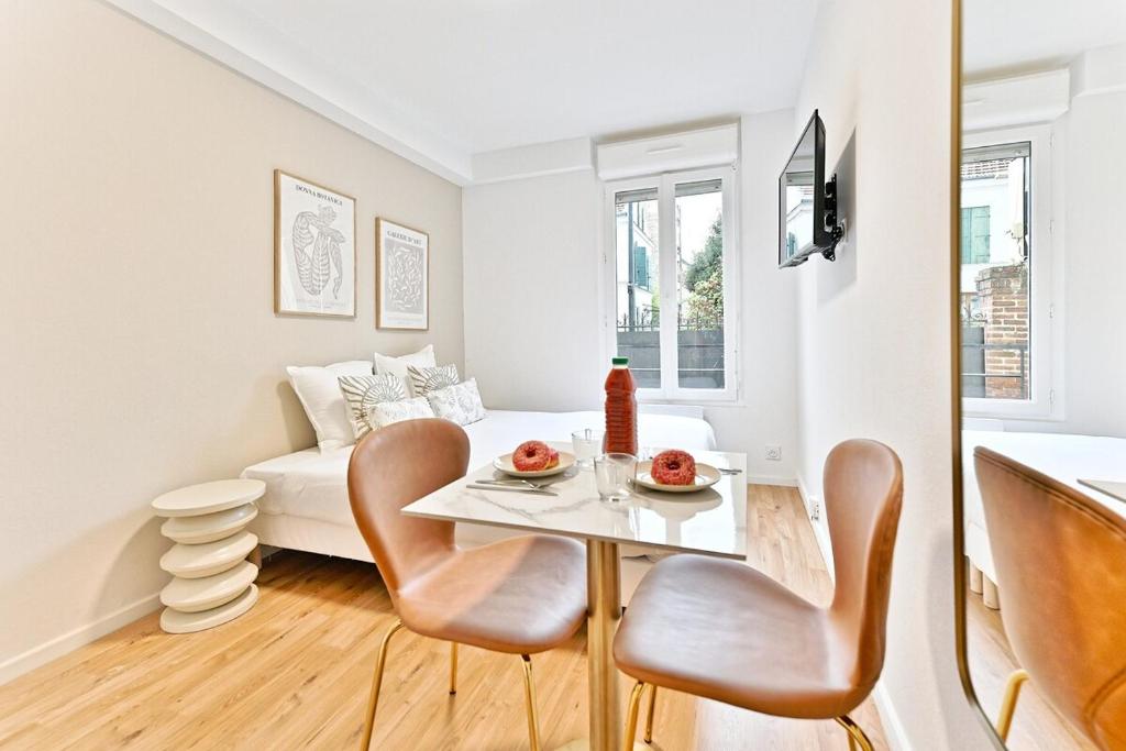 un salon avec une table, des chaises et un canapé dans l'établissement Studio paisible et calme proche Paris- V, à Asnières-sur-Seine