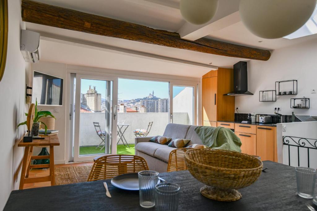 une cuisine et un salon avec un canapé et une table dans l'établissement Chez Marcel - Appart 2 ch avec clim - St Charles, à Marseille