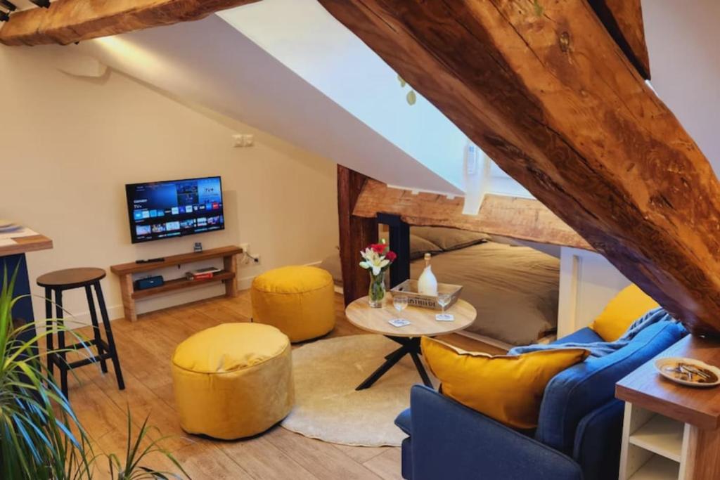 - un salon avec un canapé bleu et des fauteuils jaunes dans l'établissement Grimaldi - Sous les toits de Nice, à Nice