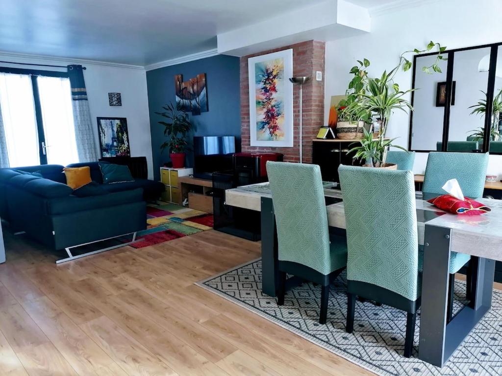 a living room with a dining table and a couch at Belle maison conviviale in Coulommiers