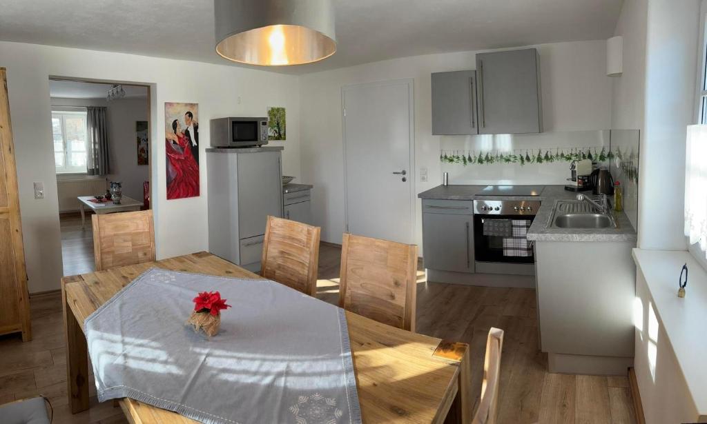 Una cocina y un comedor con mesa y sillas. en Ferienwohnung Beim Schuster, en Hitzleried