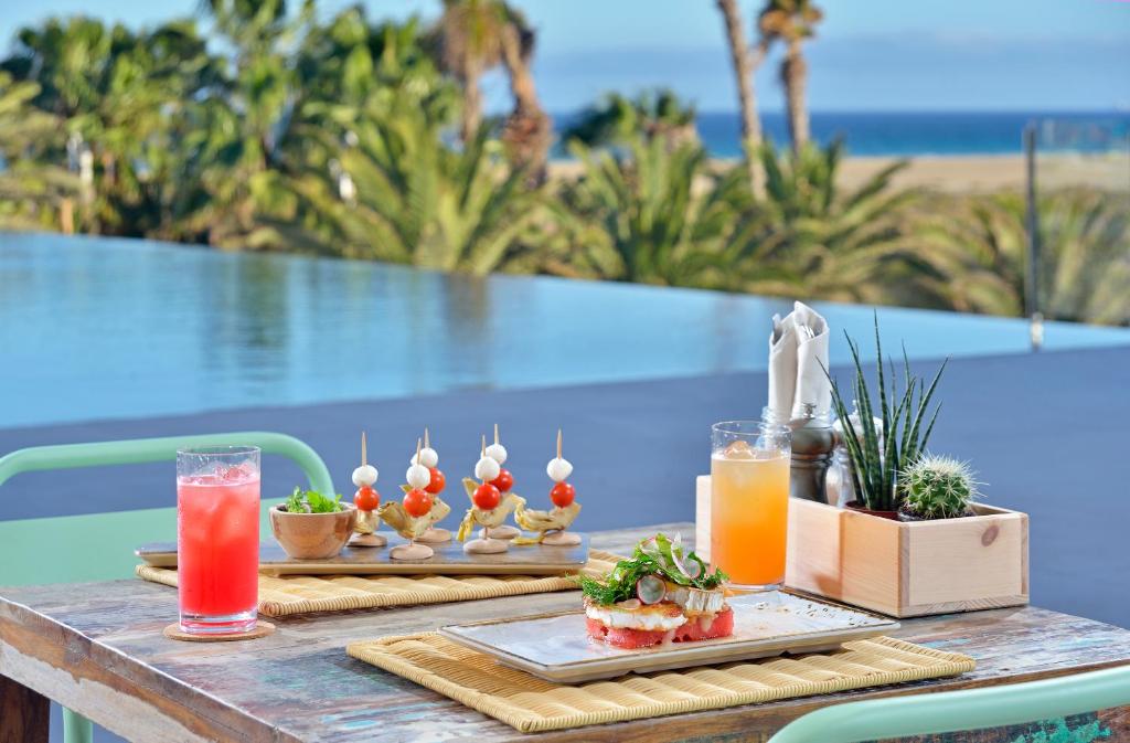 a table with two plates of food and drinks at INNSiDE by Meliá Fuerteventura – Adults Only in Costa Calma