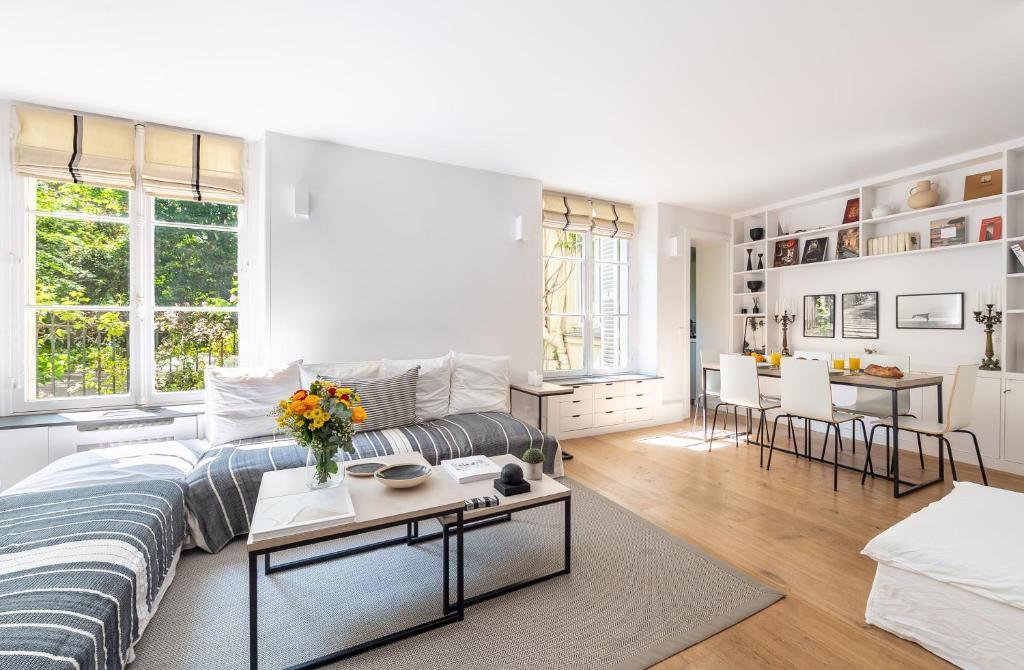un salon blanc avec un canapé et une table dans l'établissement Louvre l Souplex à 15min du Jardin du Luxembourg, à Paris