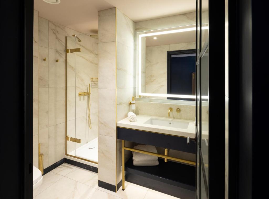 a bathroom with a sink and a shower and a mirror at The Mercantile Hotel in Dublin