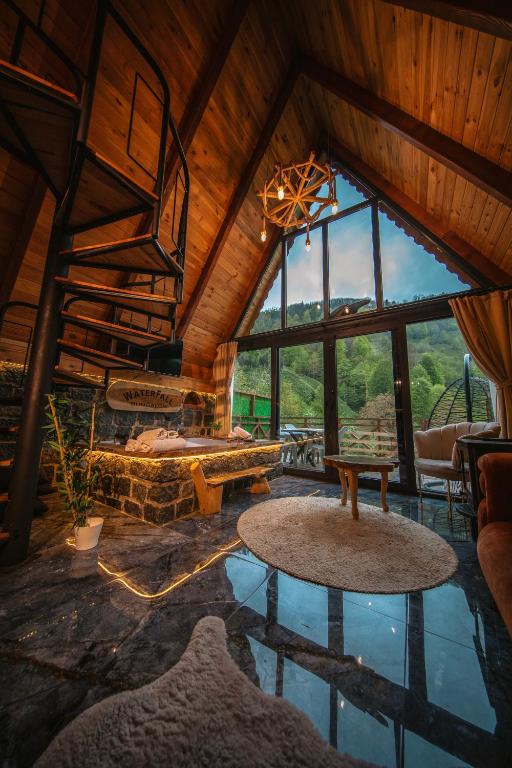 a living room with a spiral staircase in a cabin at Waterfall suit bungalov in Çamlıhemşin