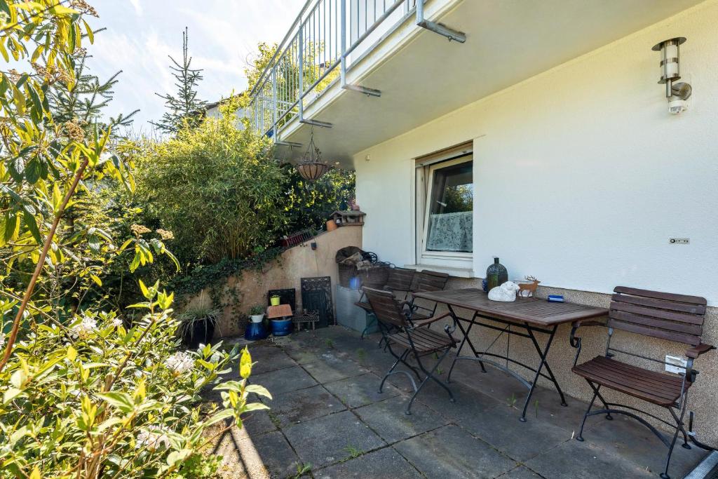 a patio with a table and chairs next to a building at Ferienwohnung Amselstraße in Marburg an der Lahn