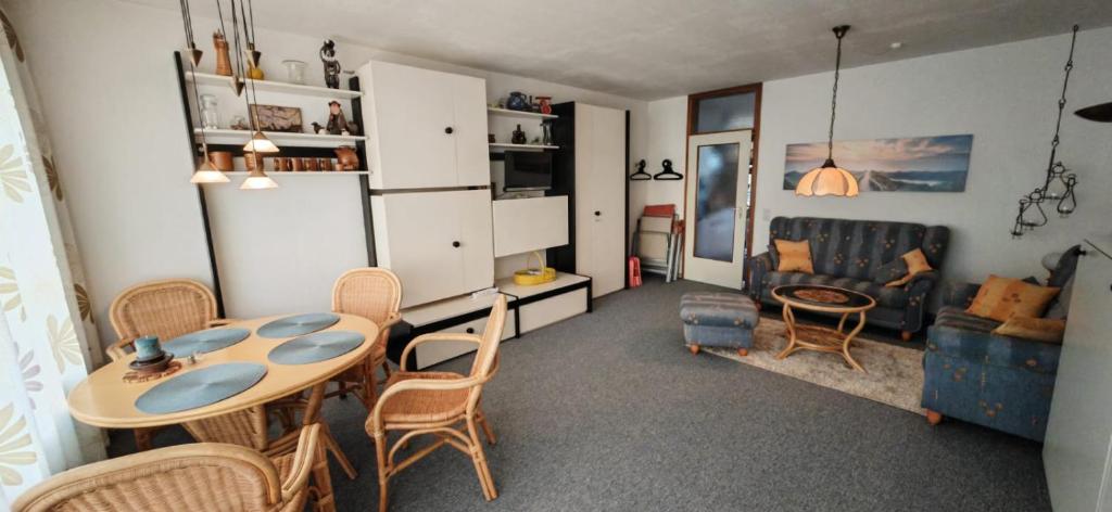 een woonkamer met een tafel, stoelen en een bank bij Vier Jahreszeiten Möwenblick in Großenbrode-Kai