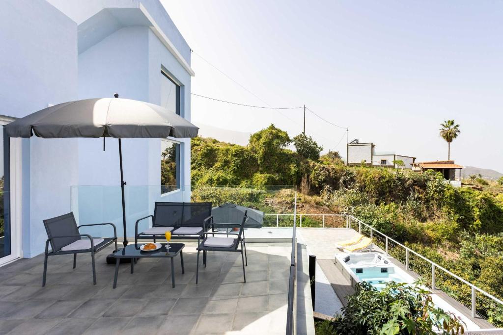 a patio with a table and chairs and an umbrella at Las Ranas 1 in El Durazno