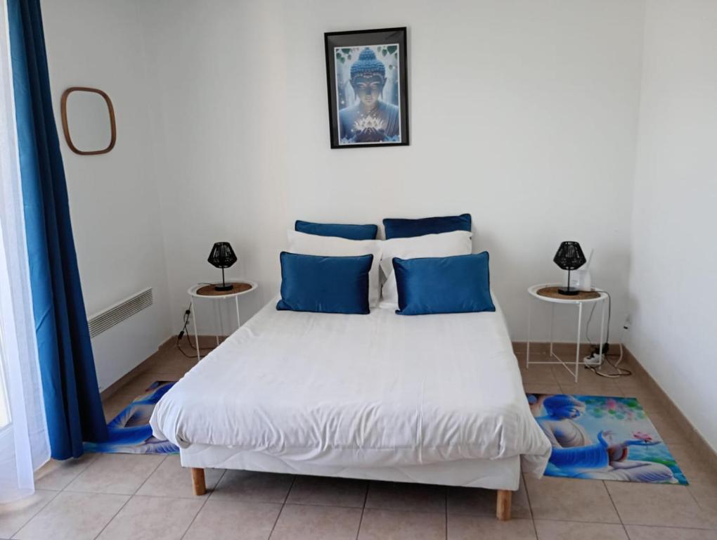 a bedroom with a large white bed with blue pillows at C210 Appartement Disneyland Paris Studio in Montévrain