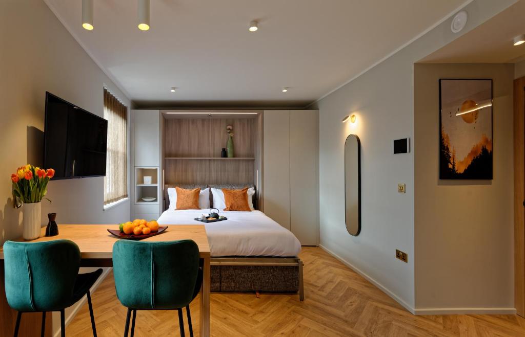 Un dormitorio con una cama y una mesa y sillas. en South Kensington Studios by D'Montrio, en Londres