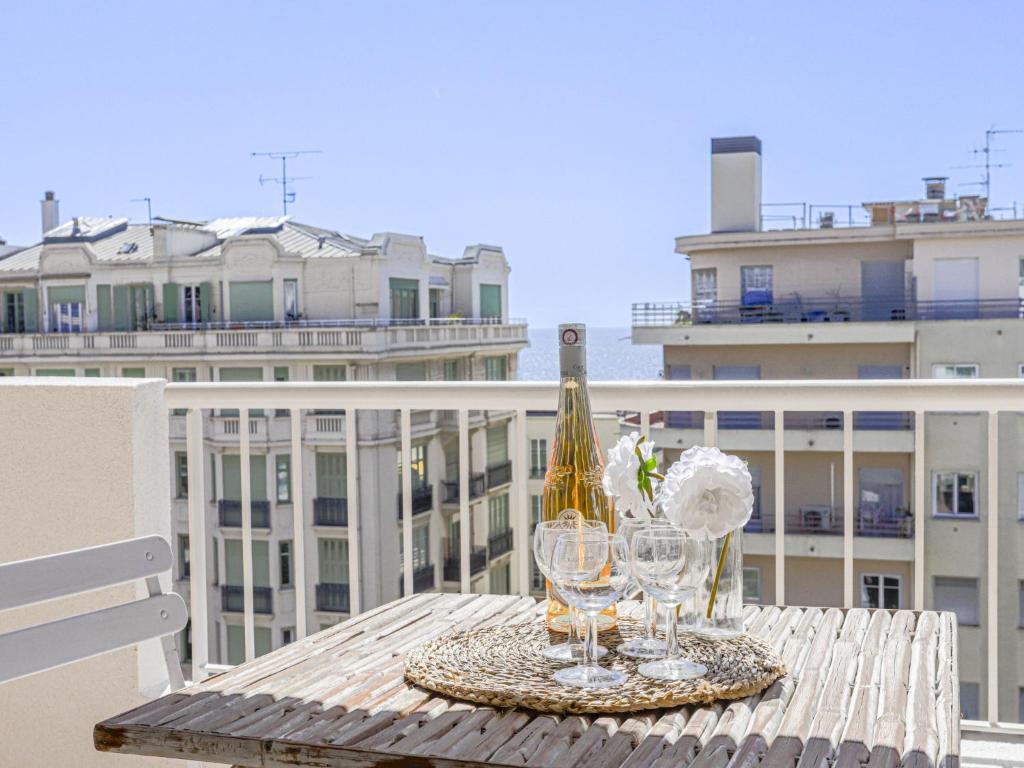 - une table avec des verres à vin et une bouteille sur le balcon dans l'établissement Apartment Baie Azur by Interhome, à Nice