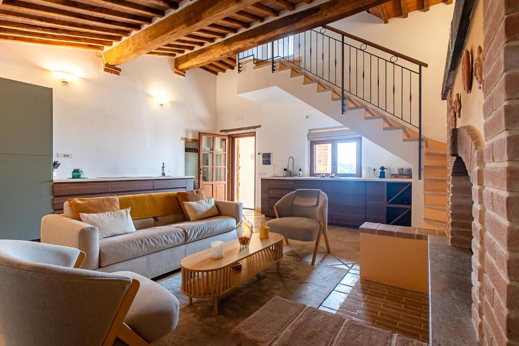 een woonkamer met een bank en een tafel bij Dimora Senea - Splendida Piscina in Rapolano Terme