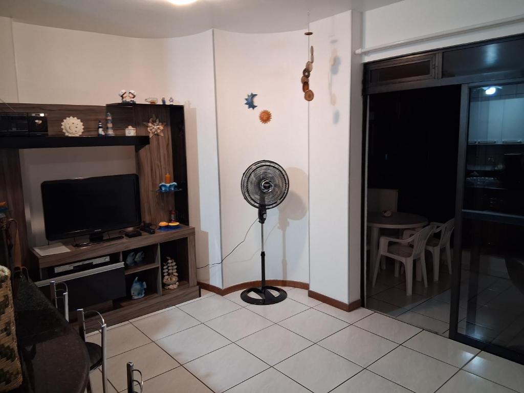 sala de estar con ventilador y TV en Apartamento em Meia Praia, Itapema, SC., en Itapema