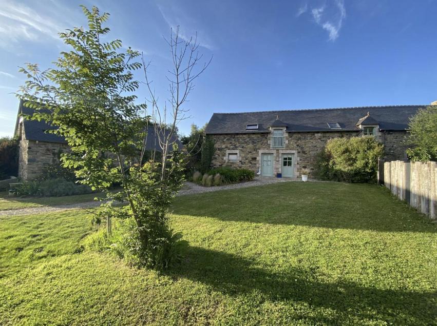 une maison en pierre avec un arbre dans la cour dans l'établissement Gite Abéria petite maison coquette, à Saint-Alban