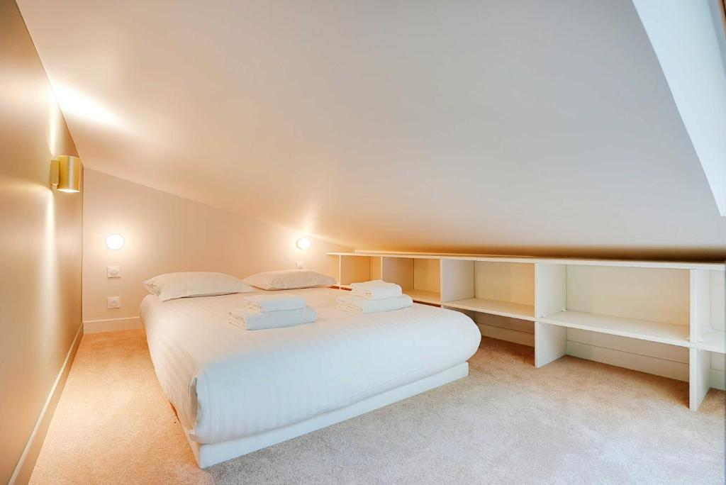 une chambre avec un lit blanc dans une pièce dans l'établissement Chic and Cosy Apartment-Canal Saint Martin, à Paris