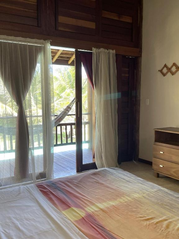 a bedroom with a bed and a sliding glass door at App Lory KiteVillage in Uruau